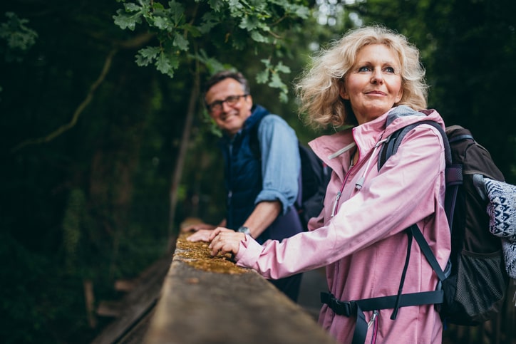 Couple looking out over a railing with hiking gear