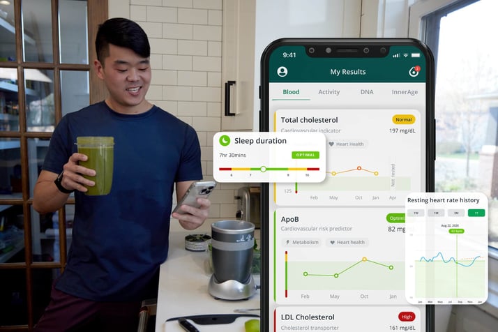 Man holding a green smoothie and looking at his phone